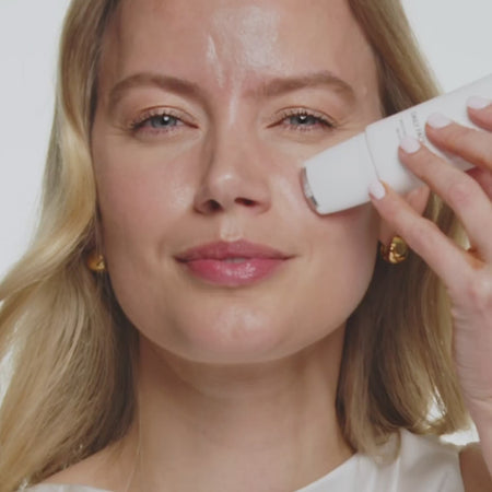 Vrouw brengt Daily Face SPF 40 aan met de verkoelende rollerball voor een stralende en beschermde zomerse glow.