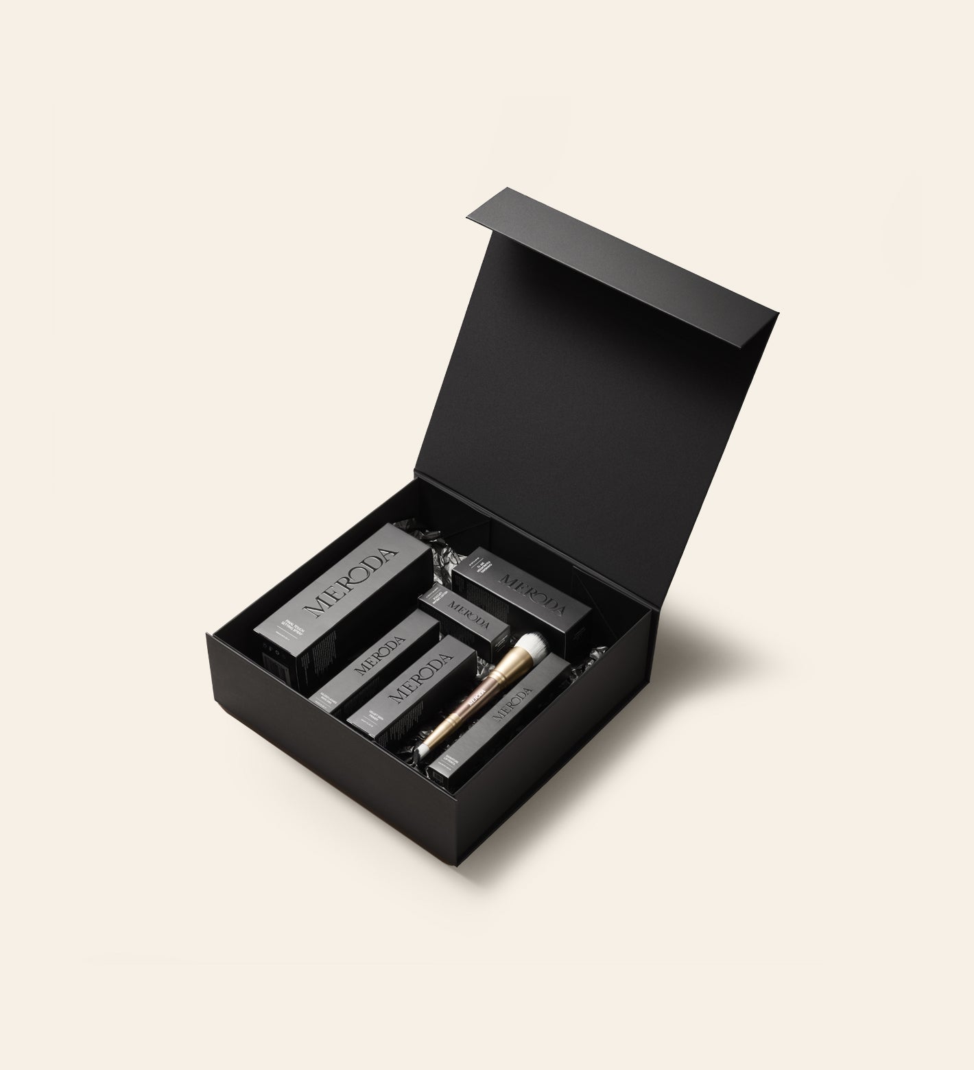 Meroda Cosmetics open matzwarte Gift Box met strakke magnetische sluiting, gevuld met make-upproducten en een kwast