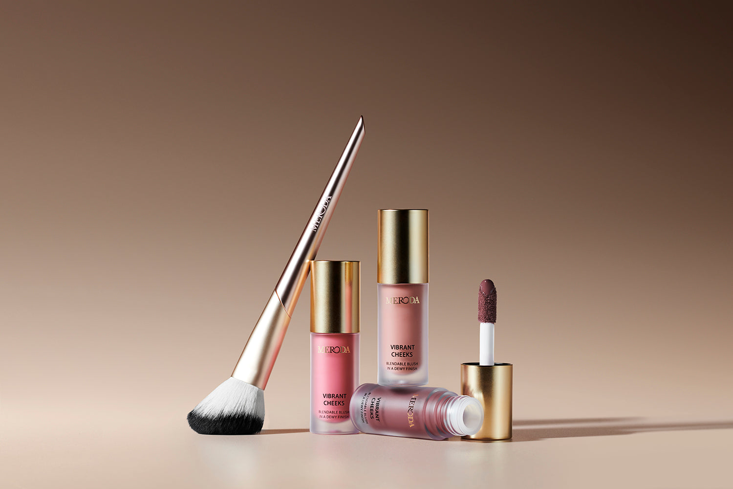 Meroda Vibrant Cheeks Blush Brush met Vibrant Cheeks Liquid Blush flesjes en applicator op een beige achtergrond.