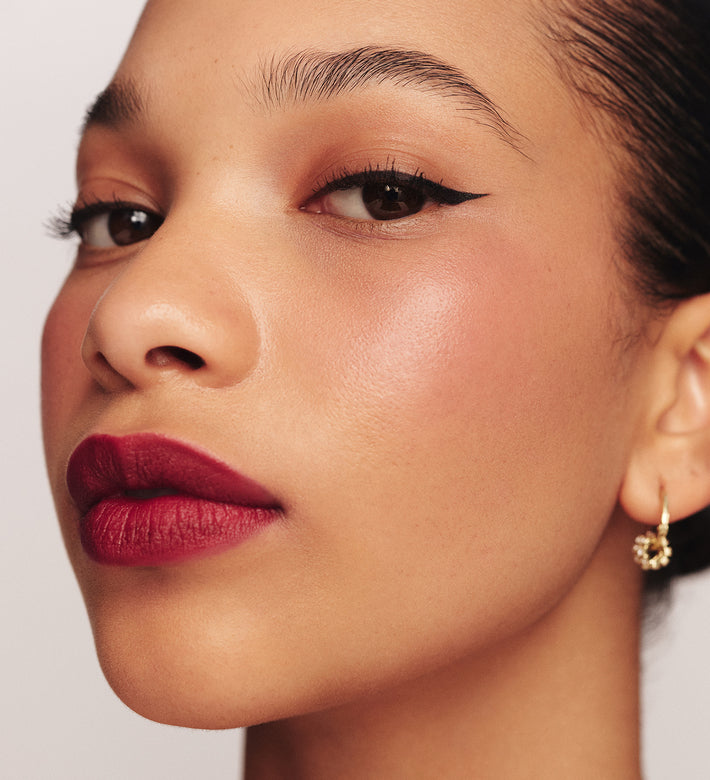Liquid Waterproof Eyeliner - It's All About The Wing op een model met een strakke zwarte wing en matte bessenkleurige lipstick